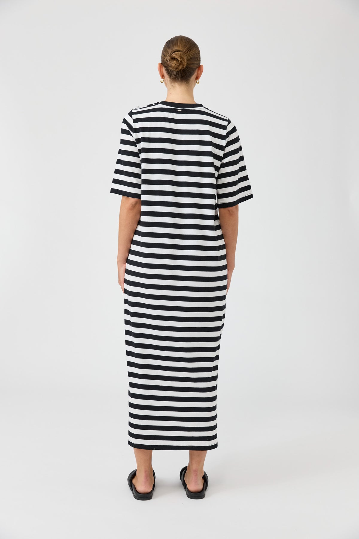 Person wearing a black and white striped dress on a white background