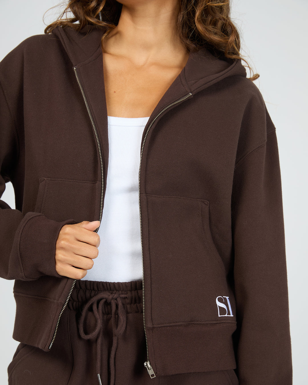 Brown hoodie with a logo on a plain background