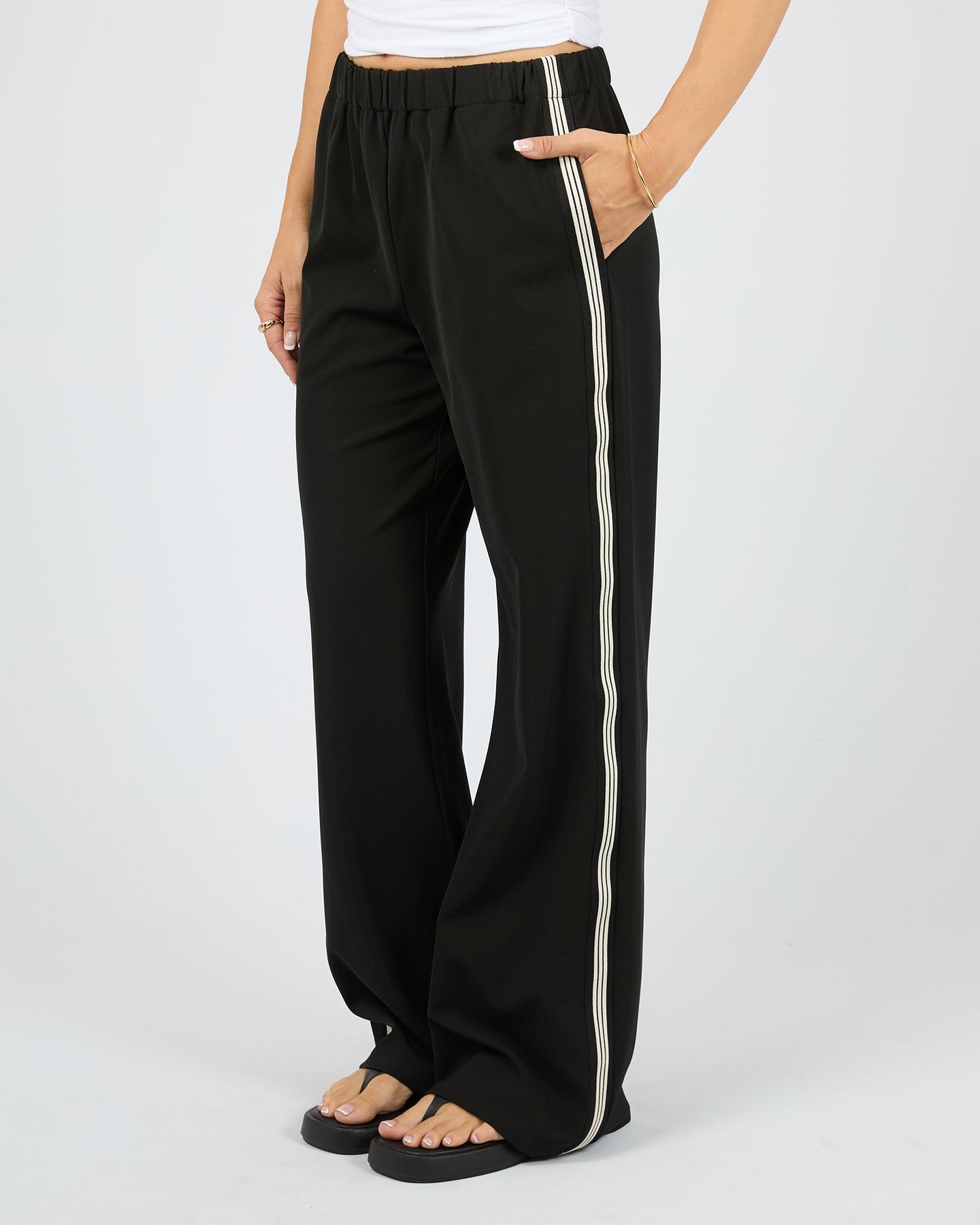 Black wide-leg pants with a white stripe on a white background