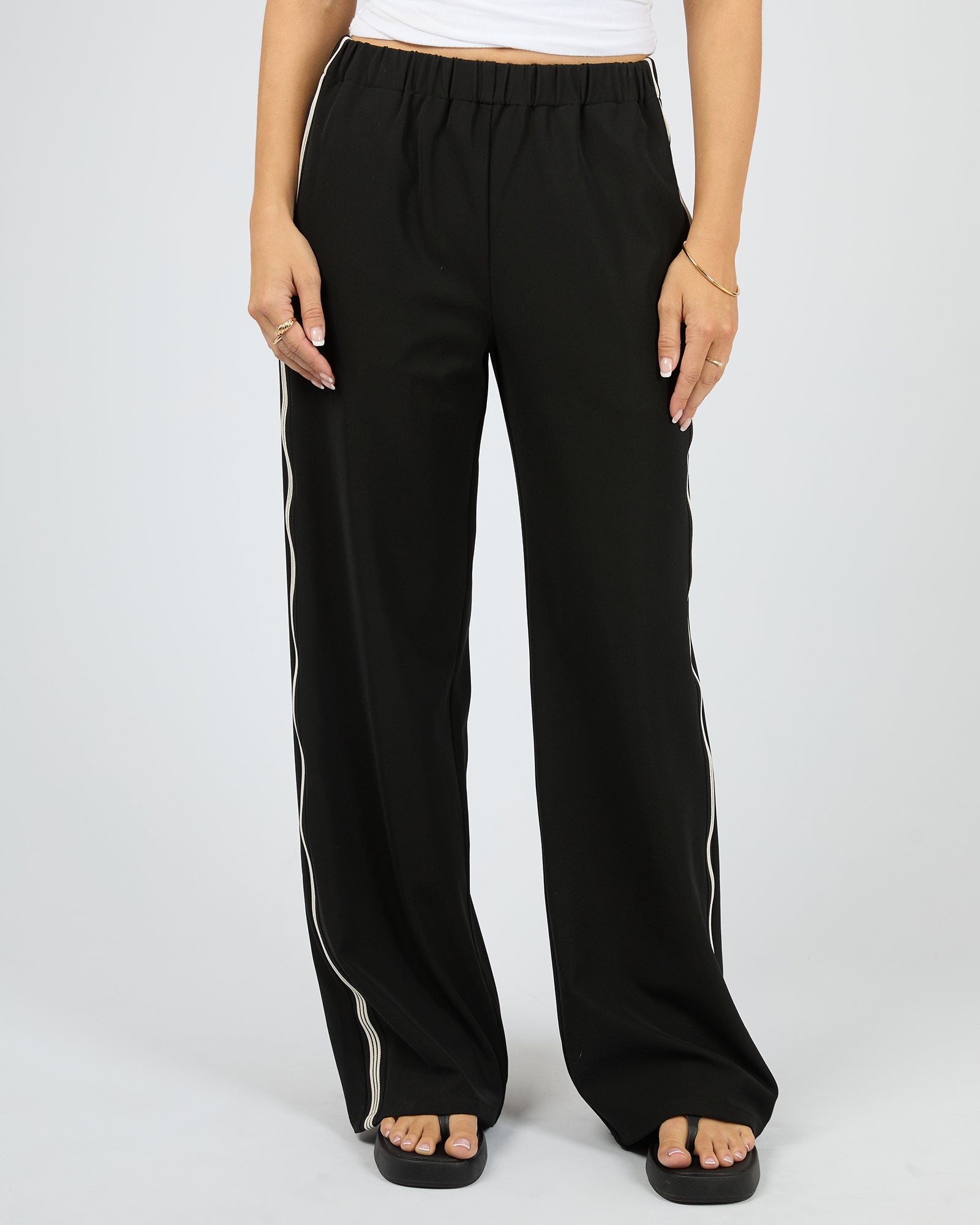 Black wide-leg pants with white stripes on a plain background