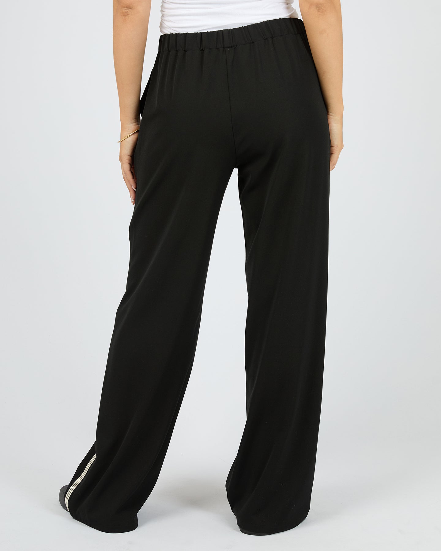 Black wide-leg pants worn by a person on a white background