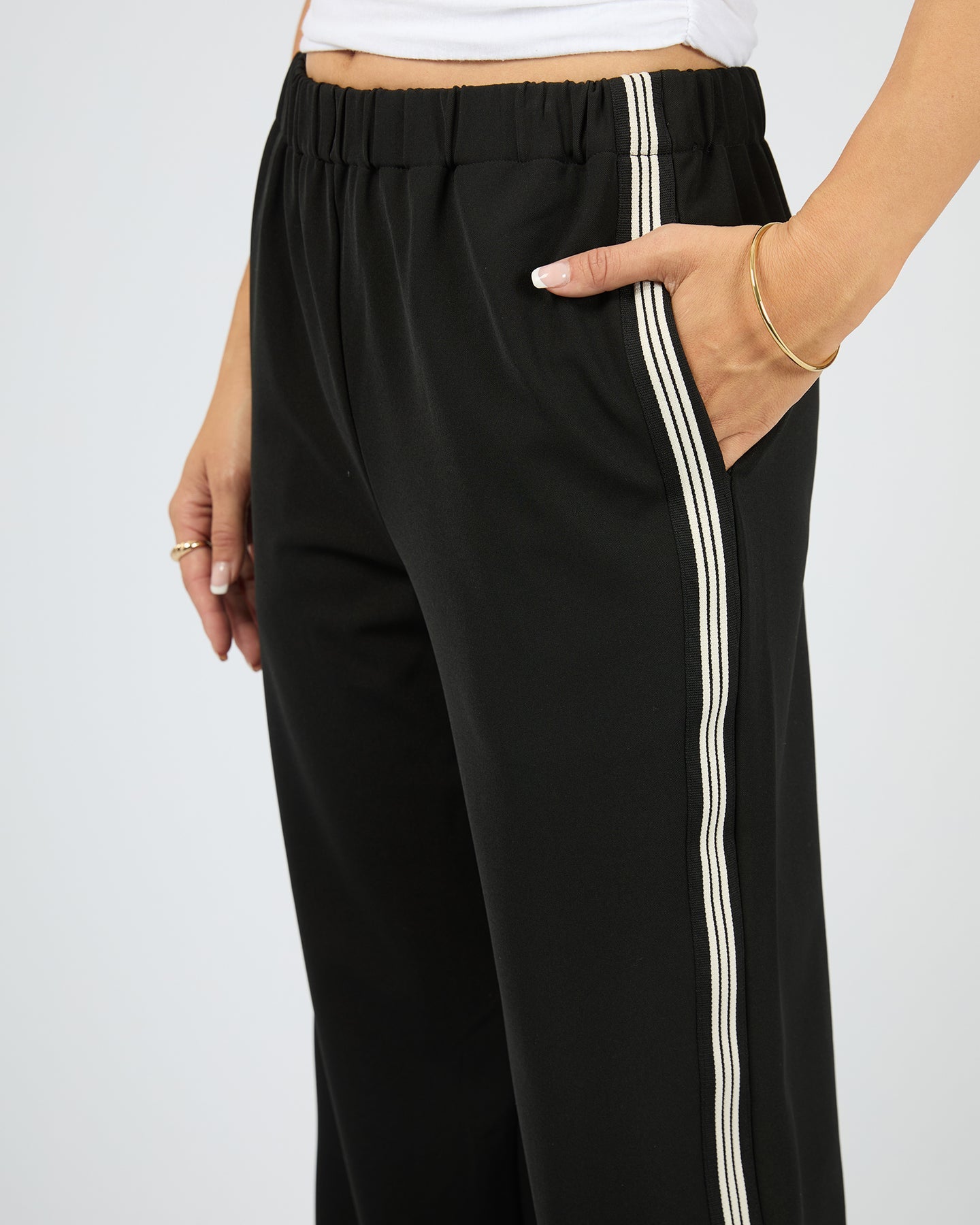 Black pants with white stripes on a plain background