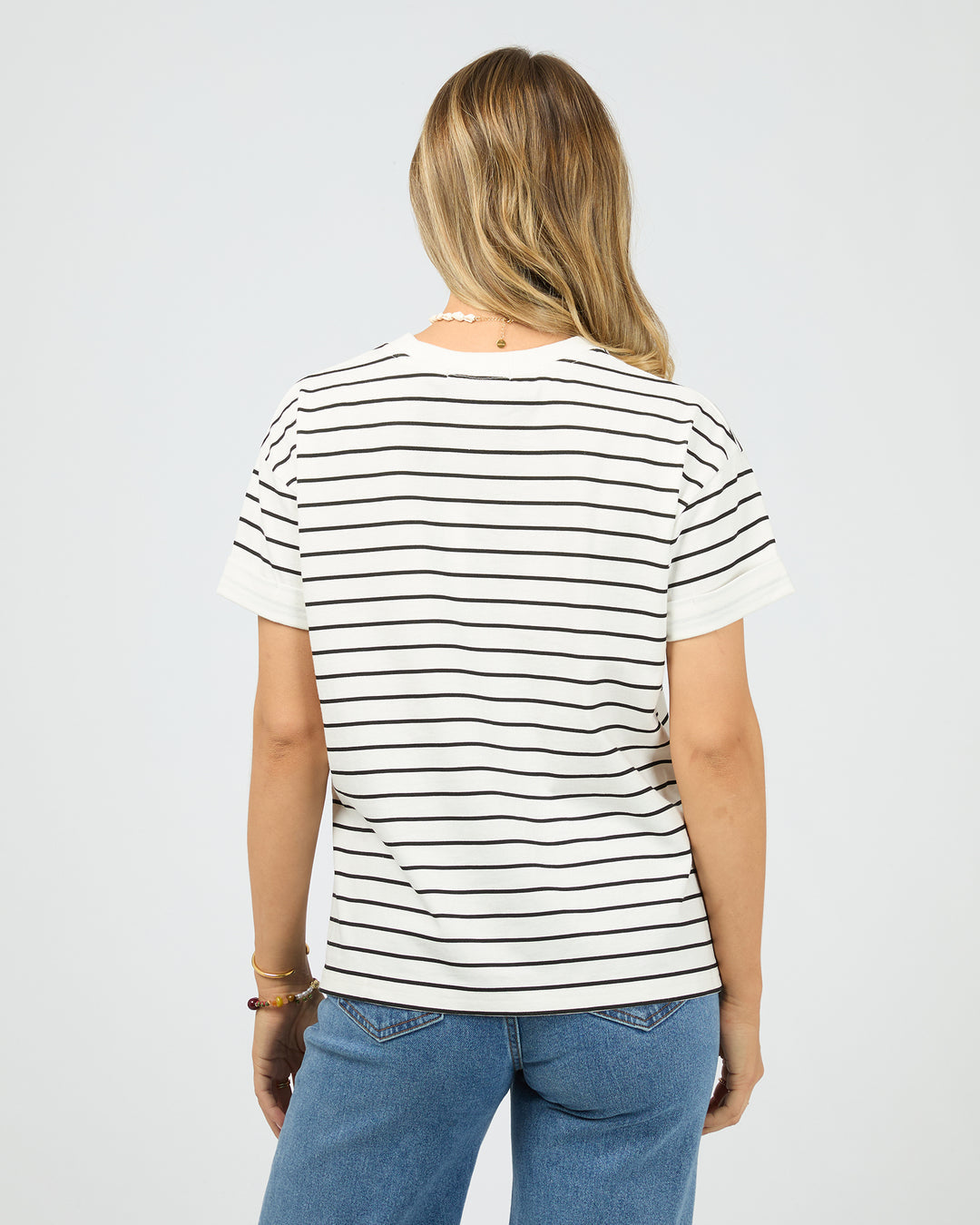 Person wearing a black and white striped t-shirt on a plain background