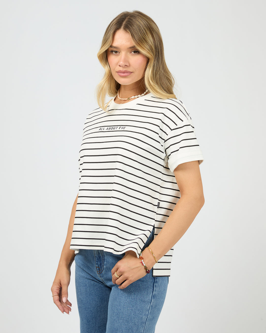 Woman wearing a black and white striped t-shirt with text on a plain background
