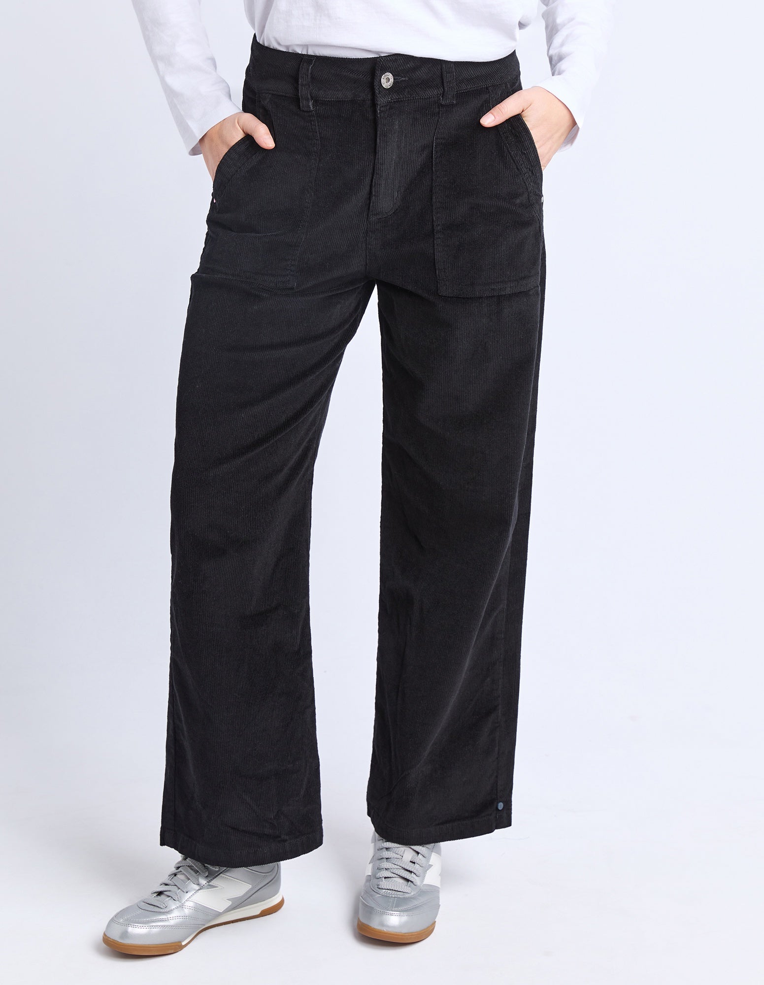 Person wearing black pants and white shirt on a white background