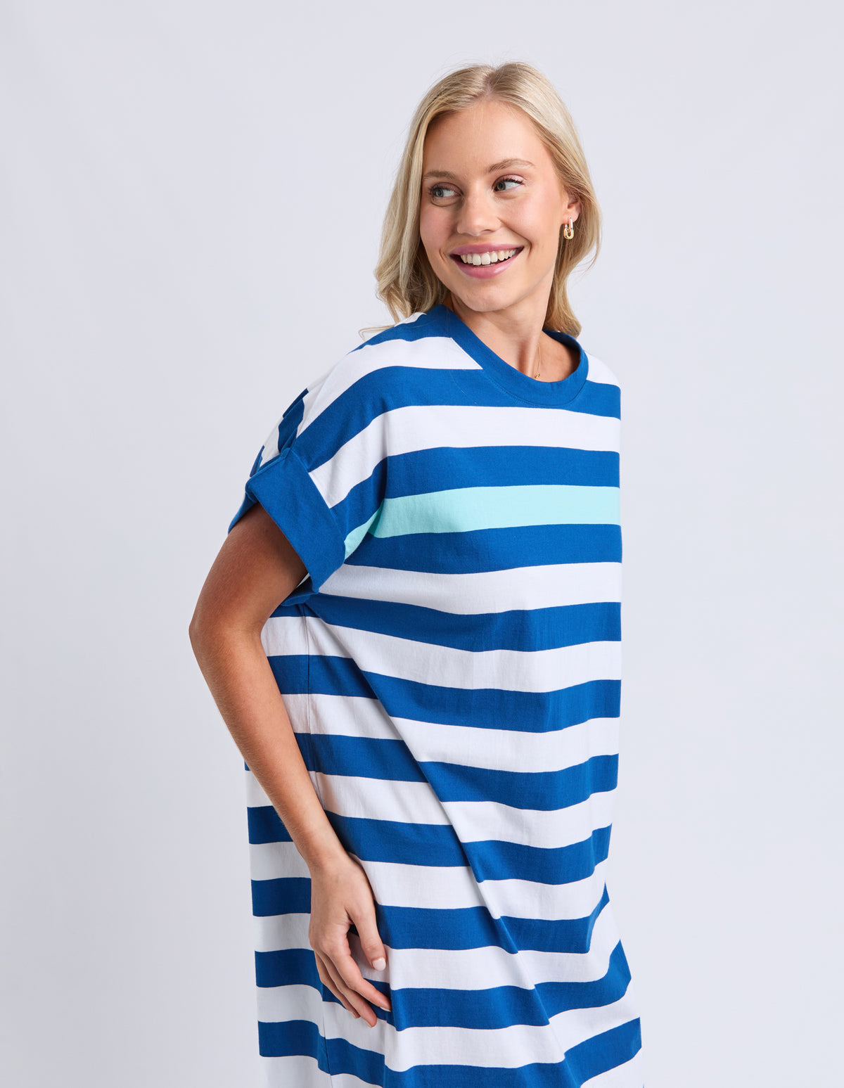 Woman wearing a blue and white striped dress on a plain background