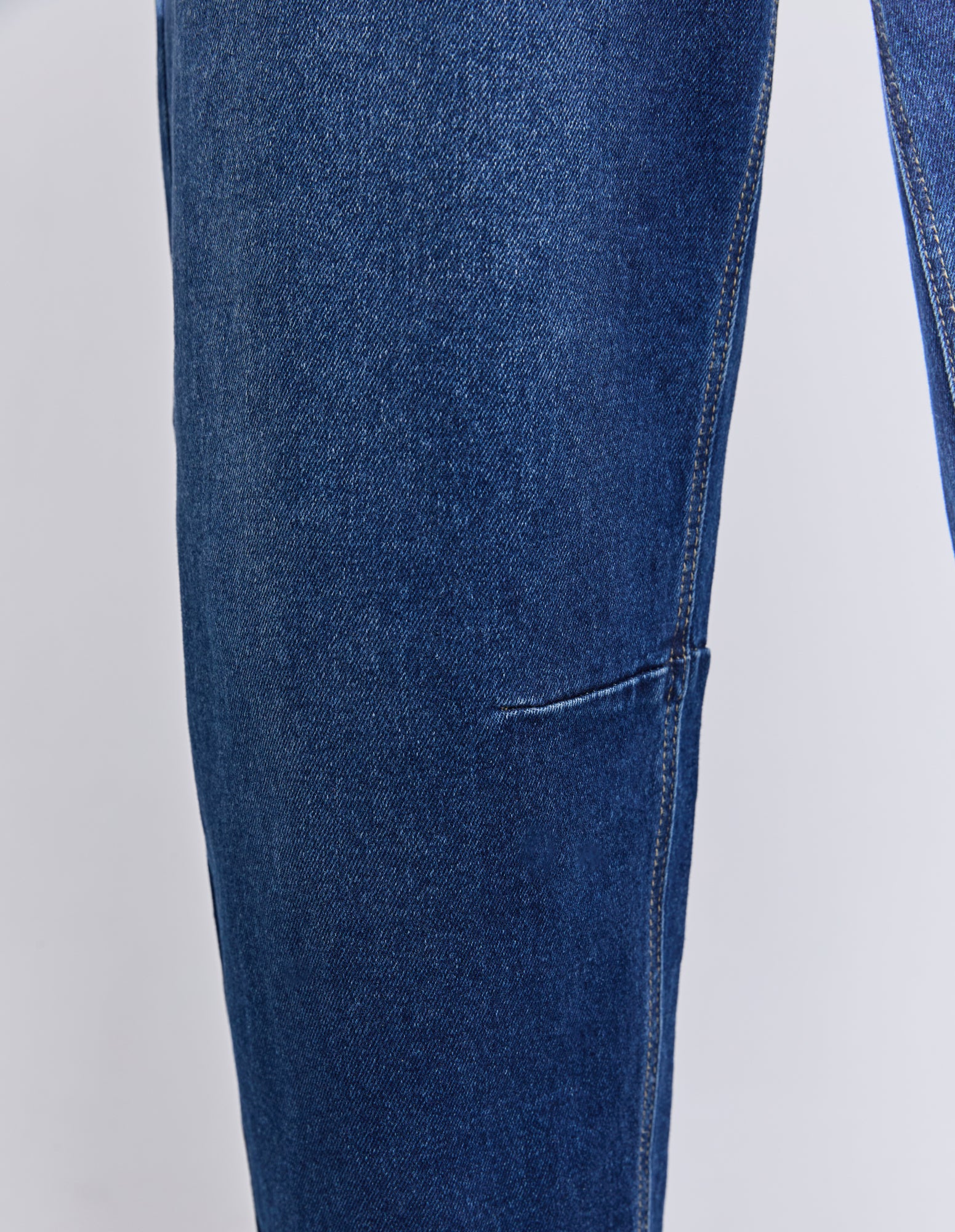 Close-up of blue jeans on a light gray background