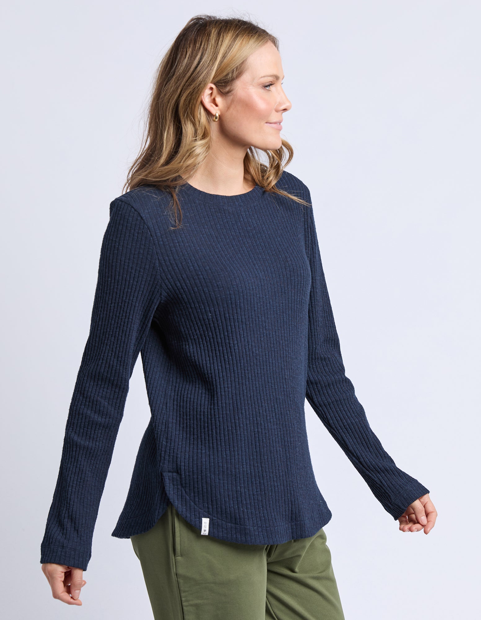 Woman wearing a navy blue long-sleeve top on a light gray background