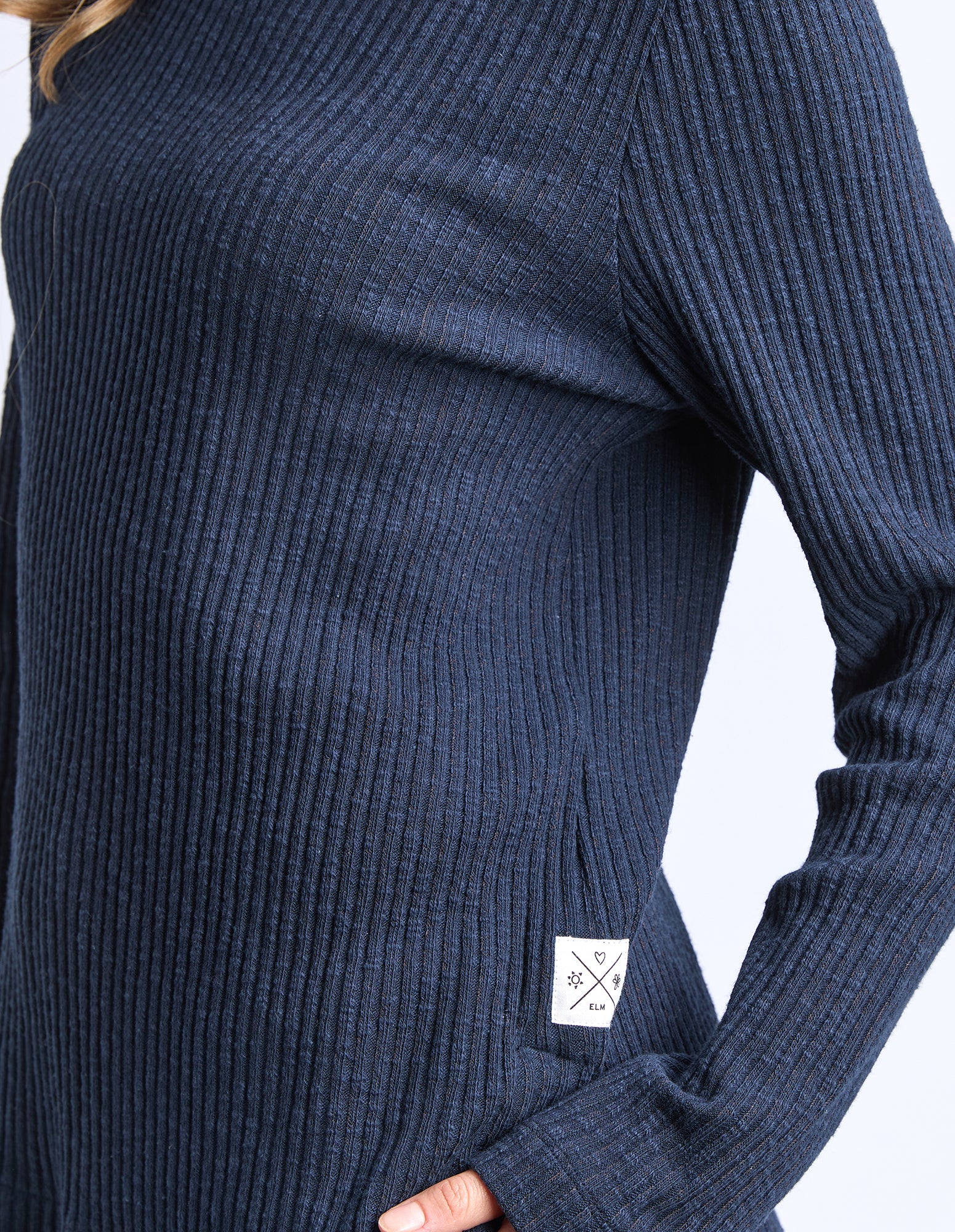 Navy ribbed sweater with a brand label on a white background