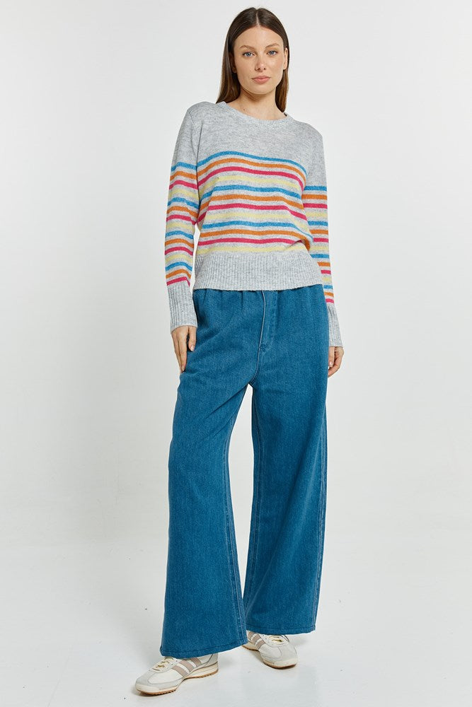 Woman wearing a striped sweater and blue jeans on a white background