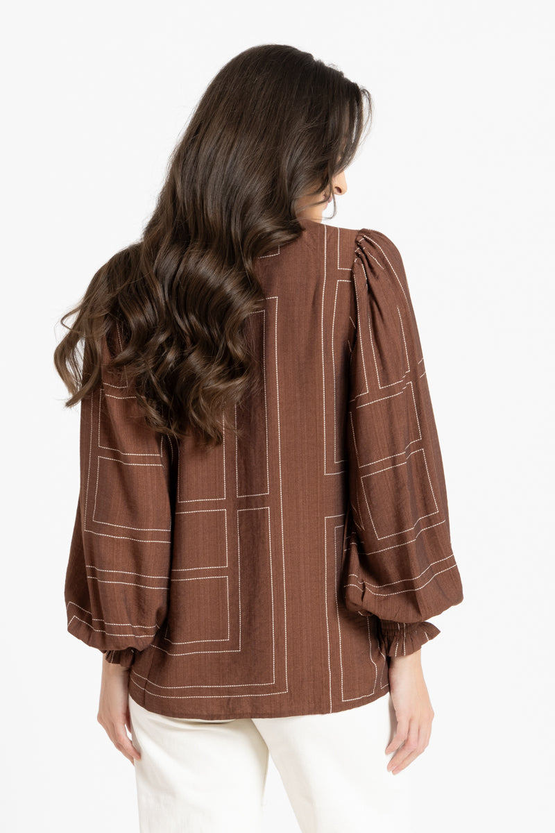 Rear of women in brown blouse