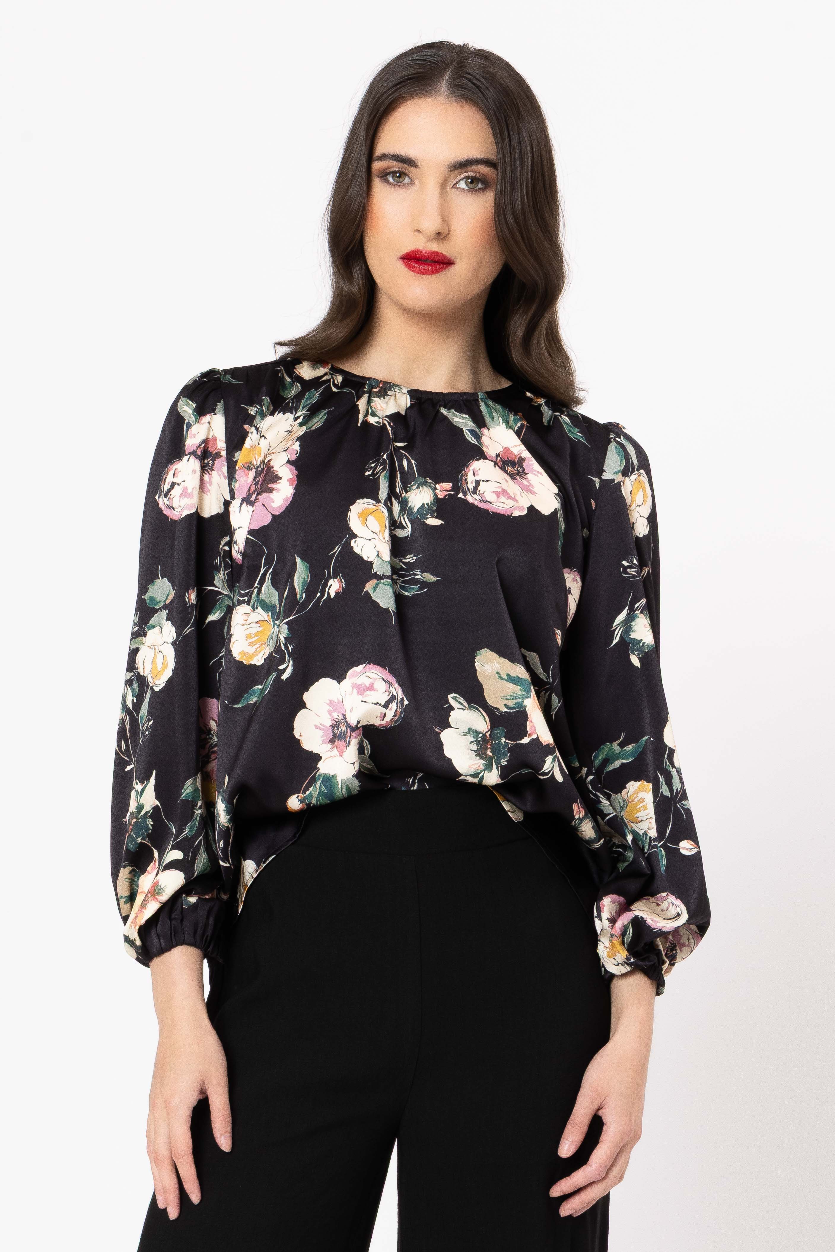 Woman wearing a black floral blouse against a white background