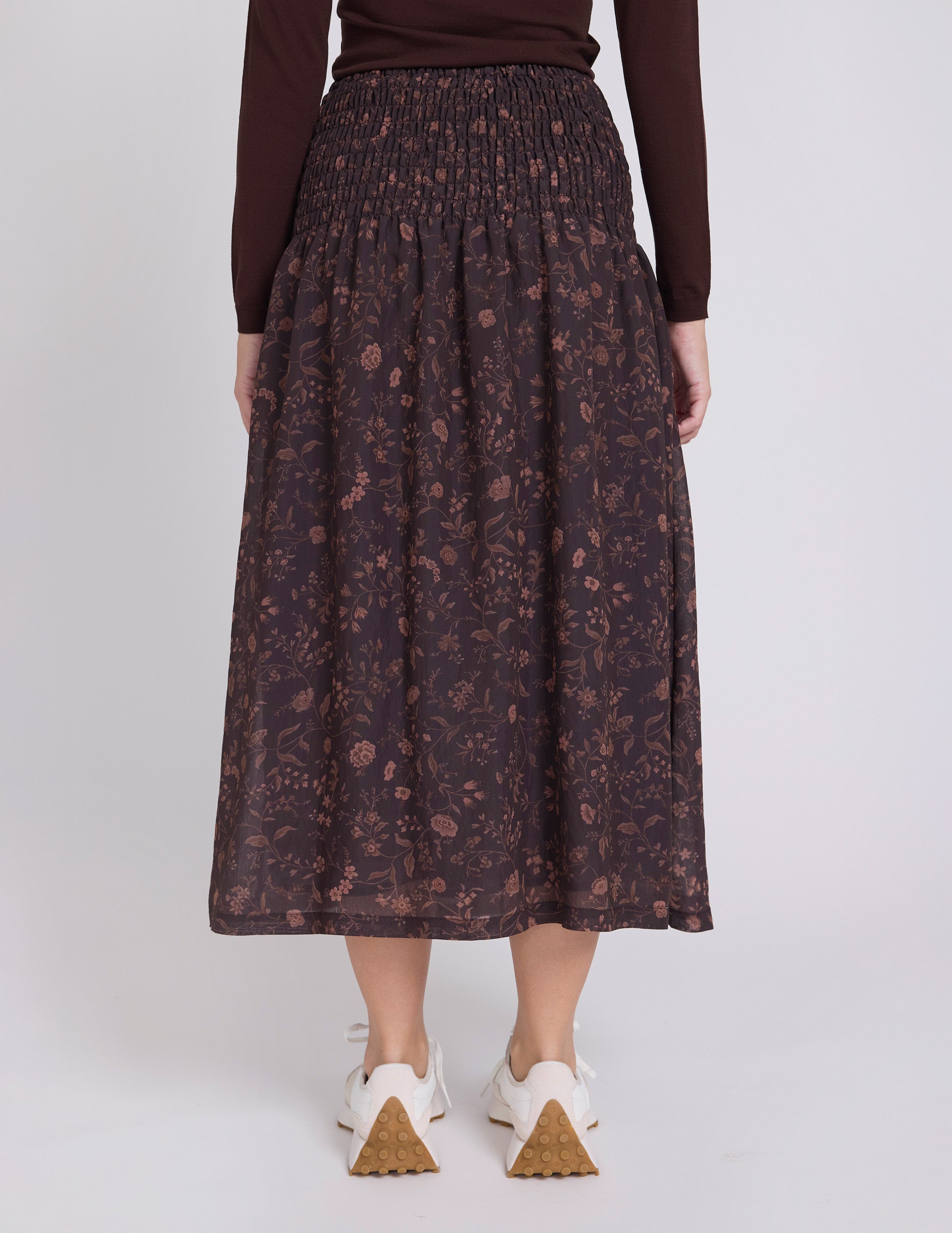 Person wearing a patterned skirt on a white background