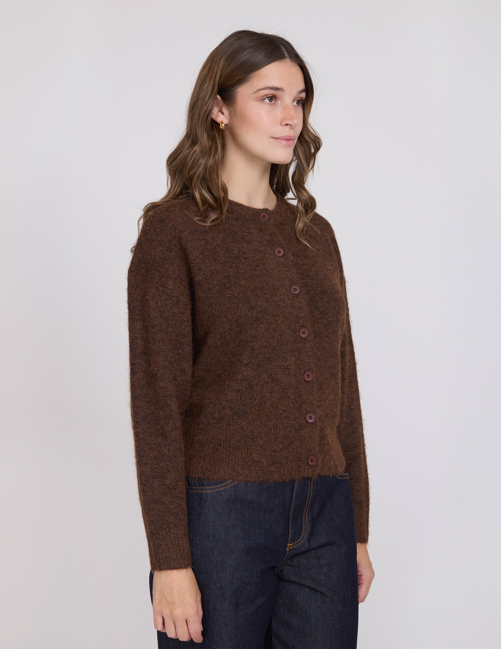 Woman wearing a brown knitted sweater against a white background