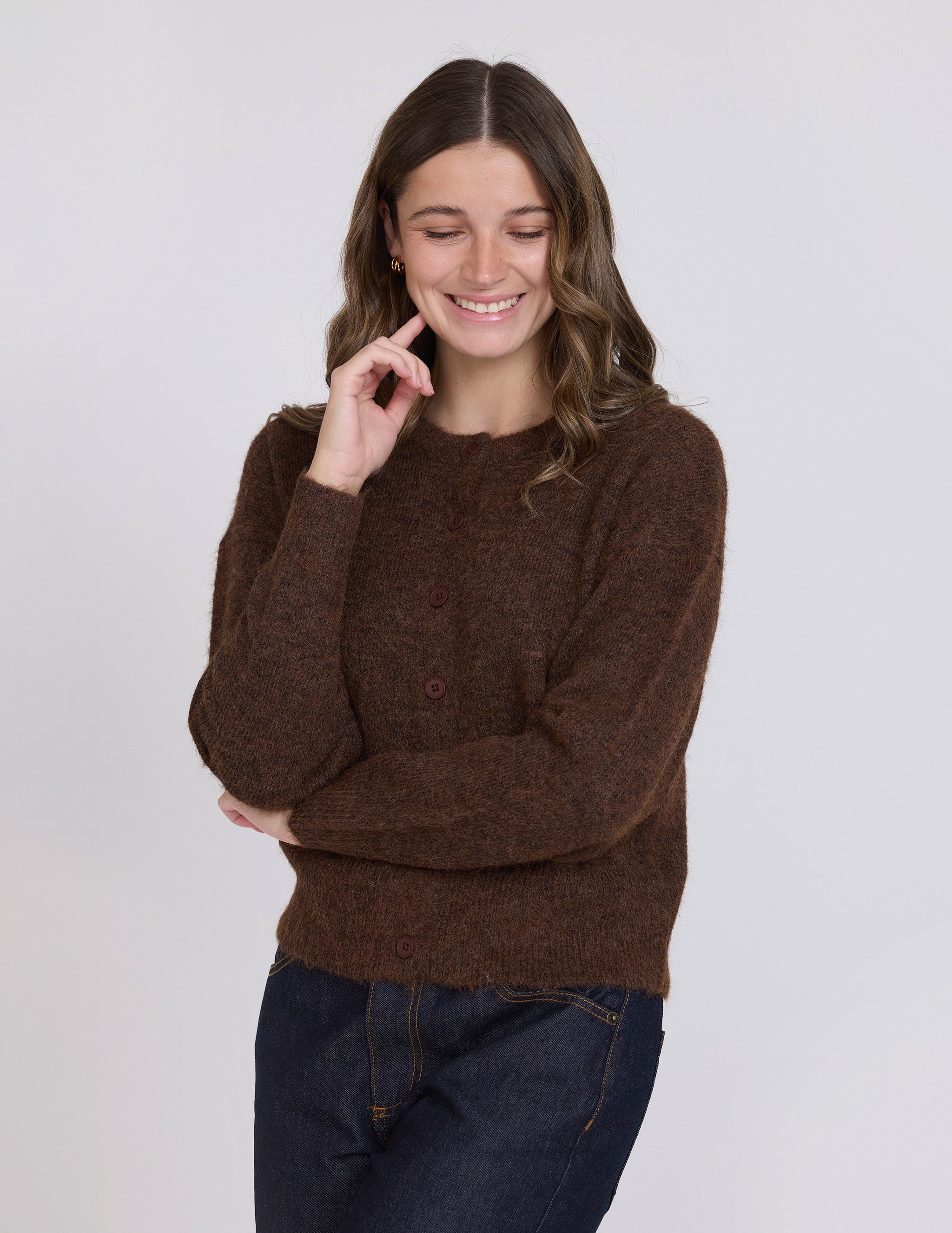 Woman wearing a brown sweater against a white background