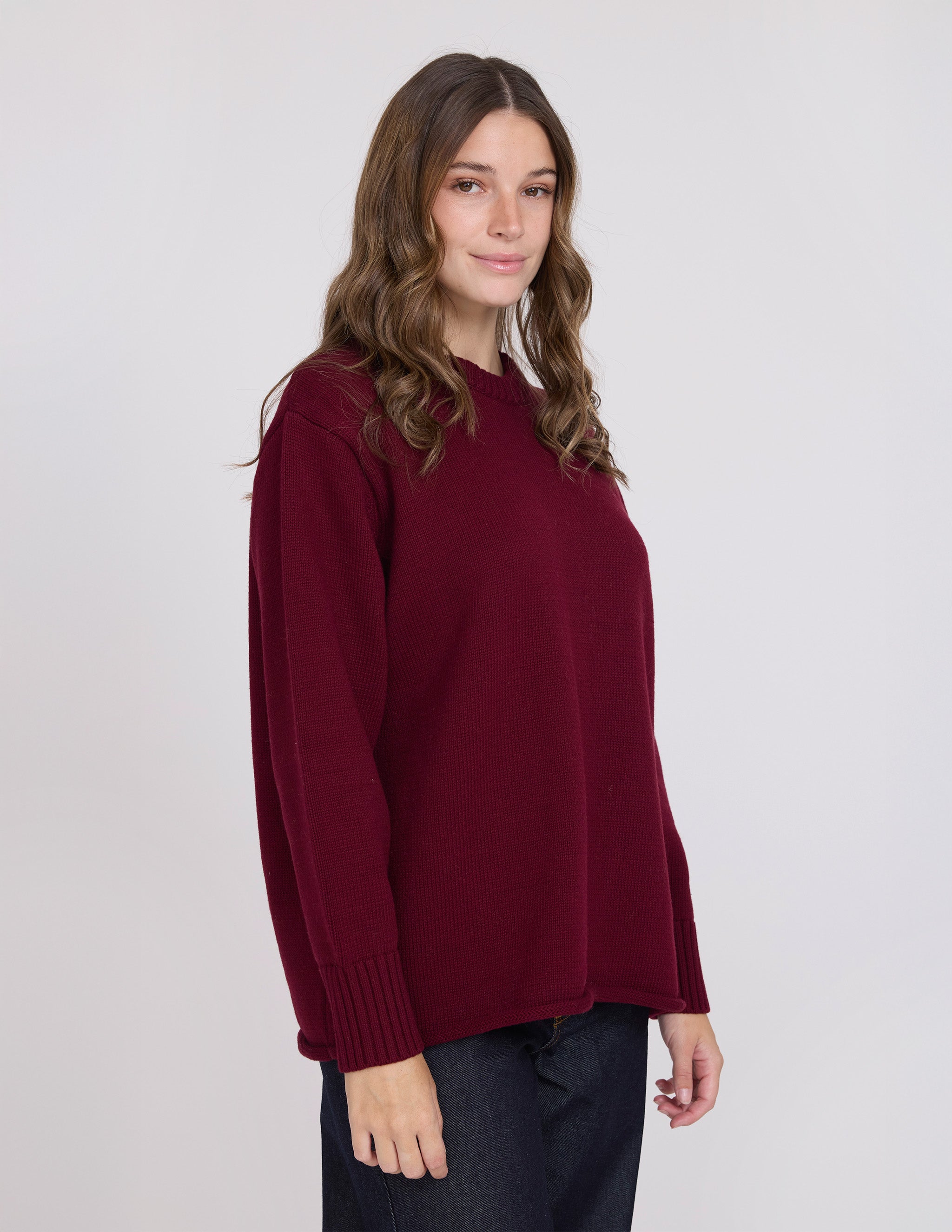Woman wearing a burgundy sweater against a white background