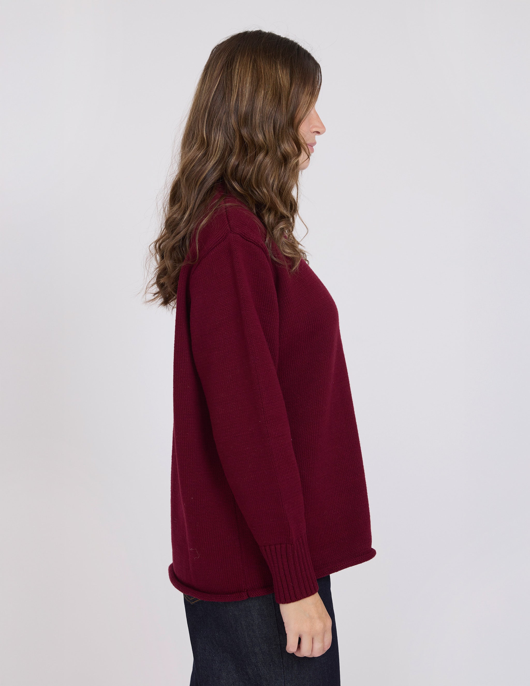 Woman wearing a burgundy sweater against a white background
