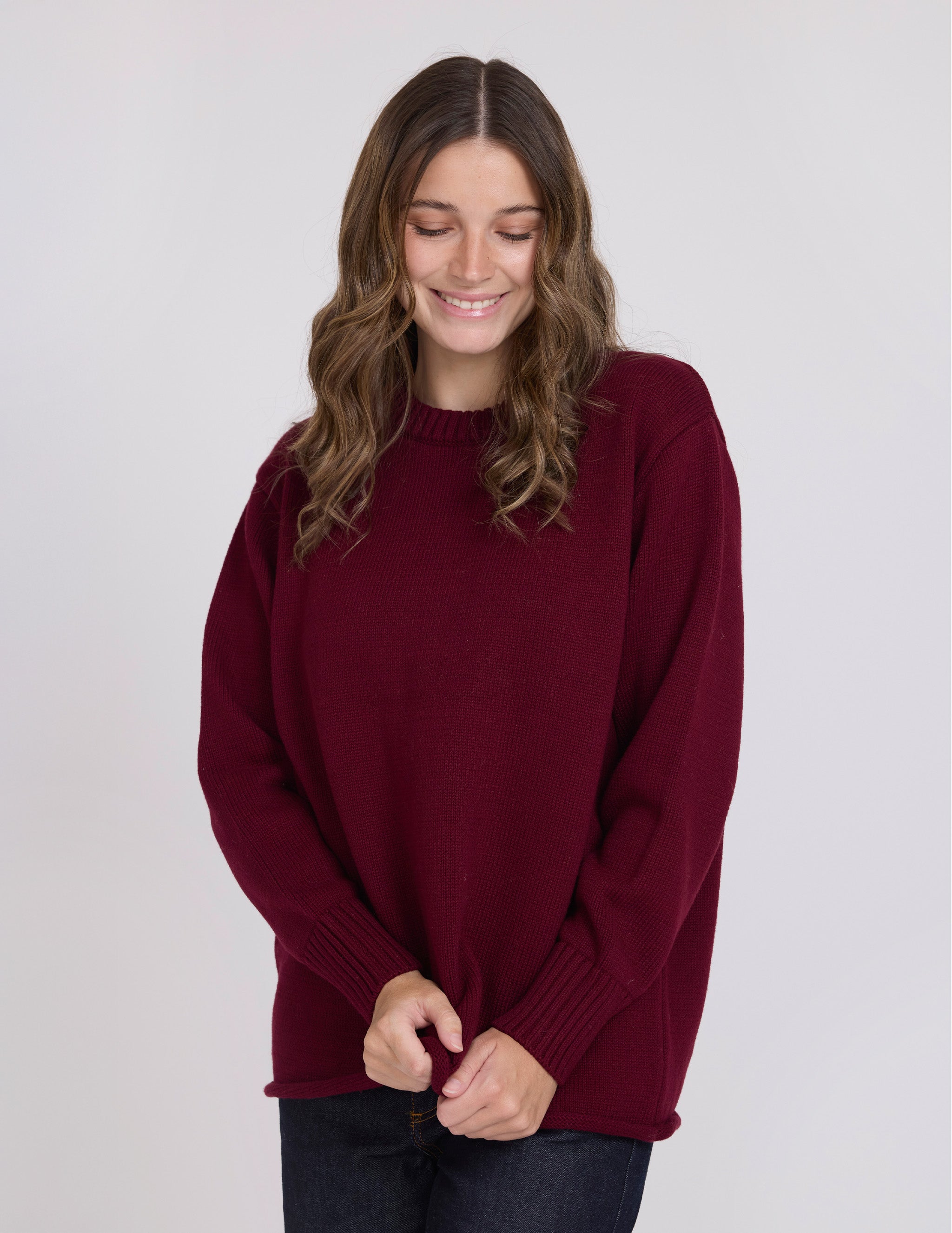 Woman wearing a burgundy sweater against a plain background