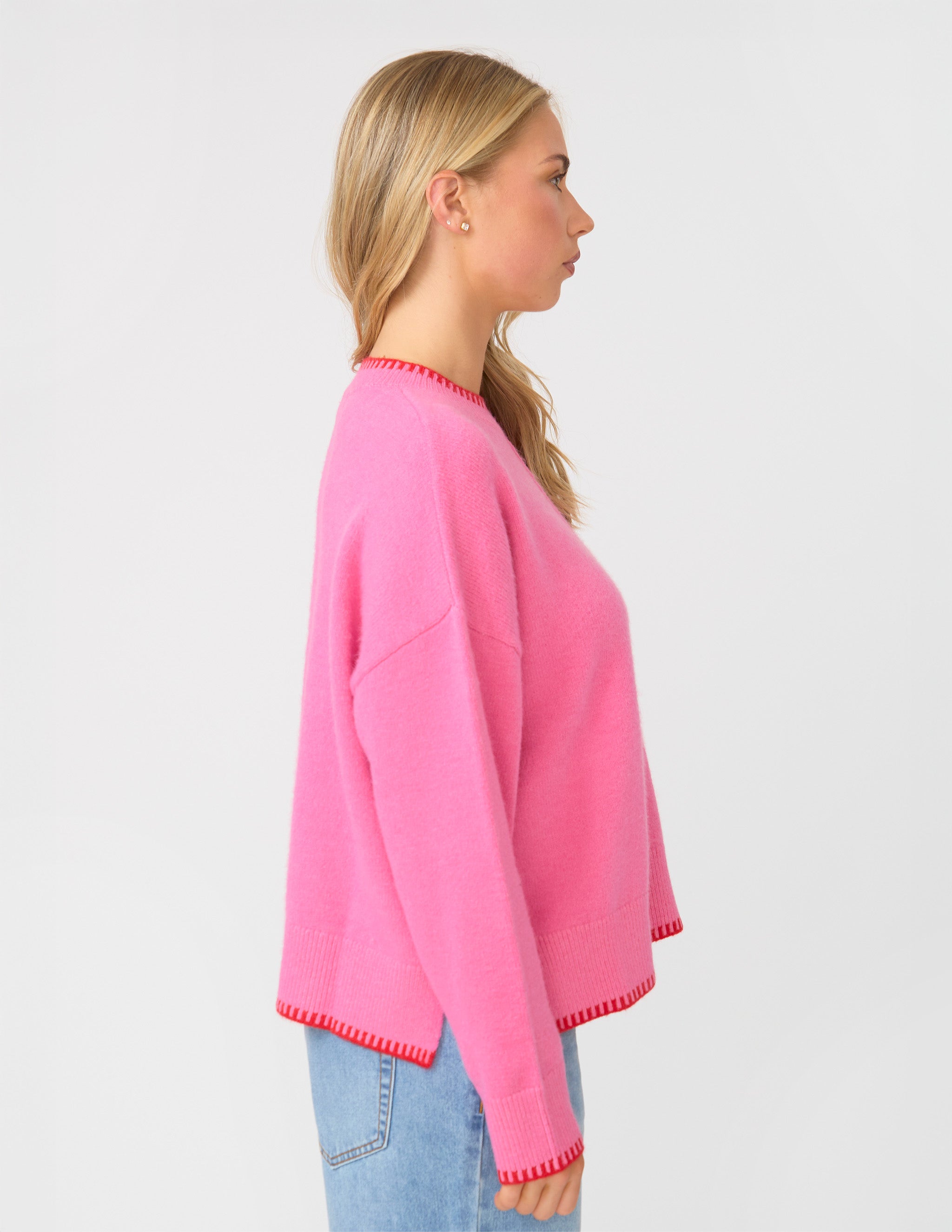 Woman wearing a pink sweater with a white background