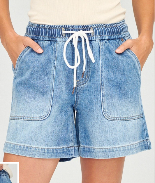 Light blue denim shorts with a white drawstring, shown on a model with hands in pockets against a light gray background.