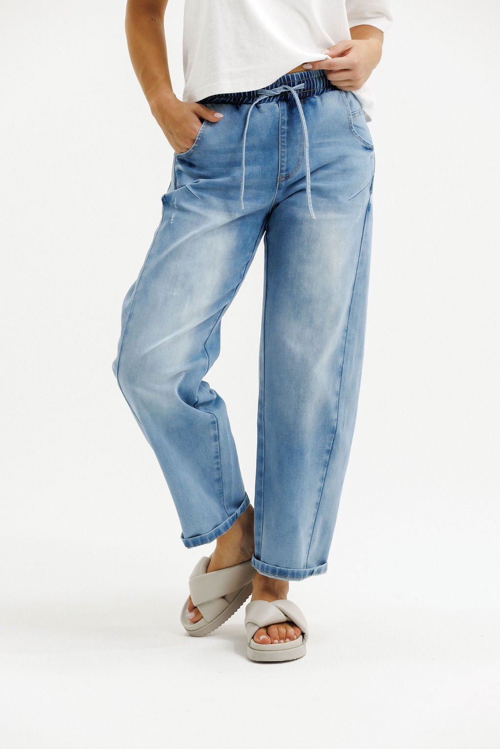 Light blue jeans worn by a person on a white background