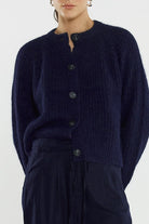 Person wearing a dark blue cardigan on a white background