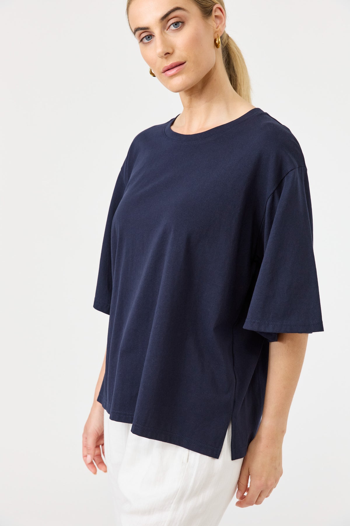 Woman wearing a navy blue oversized t-shirt on a white background