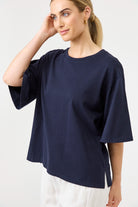 Woman wearing a navy blue oversized shirt on a white background