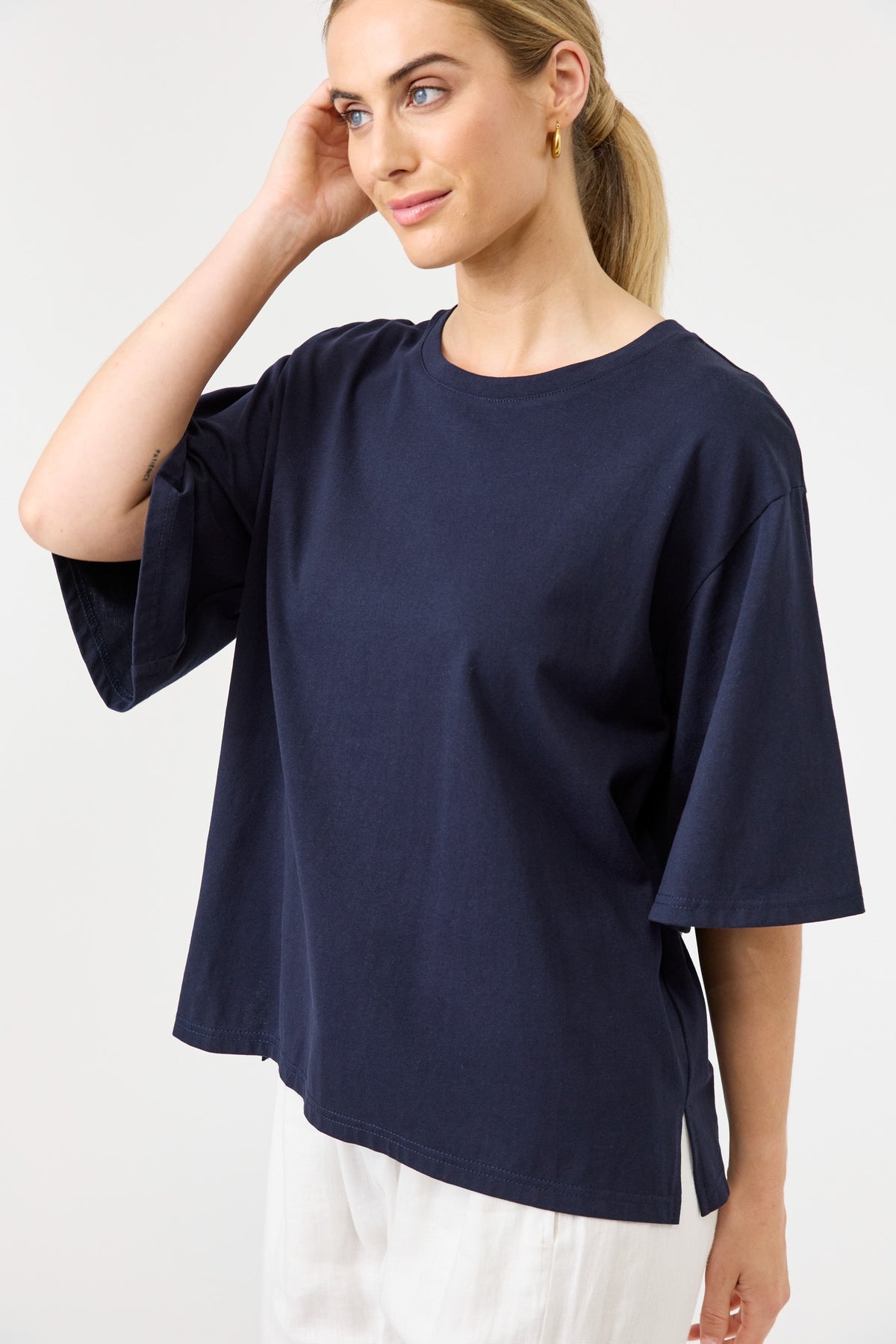 Woman wearing a navy blue oversized shirt on a white background