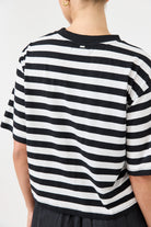 Person wearing a black and white striped shirt on a plain background