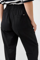 Black pants worn by a person on a white background