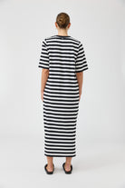 Person wearing a black and white striped dress on a white background