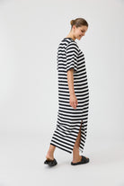 Woman wearing a black and white striped dress on a white background