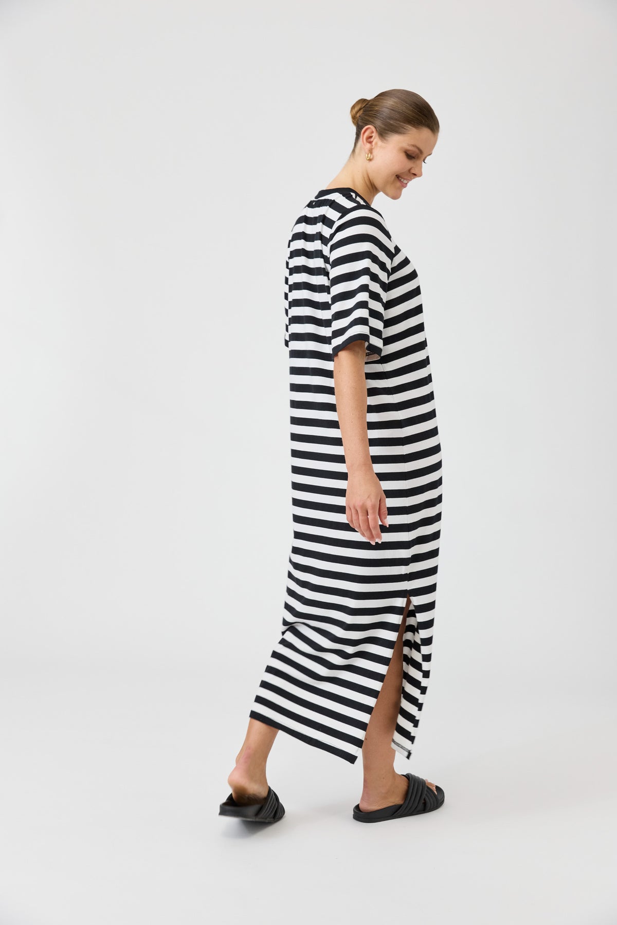 Woman wearing a black and white striped dress on a white background