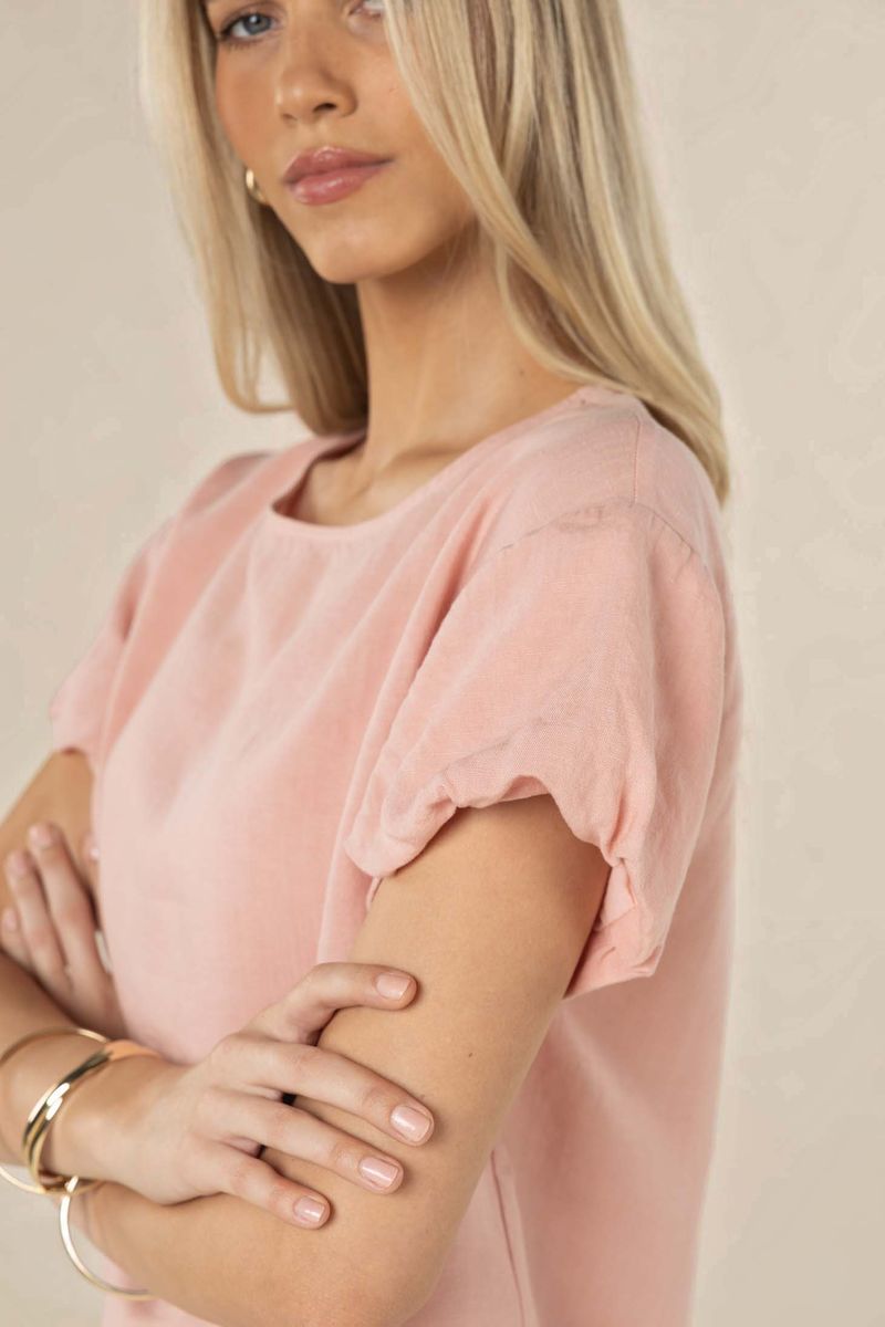 Woman wearing a pink top with a neutral background