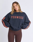 woman wearing navy sweatshirt with orange writing