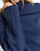 Close-up of a blue knitted sweater with a high collar.