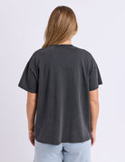 Person wearing a plain black t-shirt on a light gray background