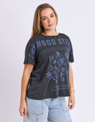 Woman wearing a black t-shirt with blue graphics and text on a light gray background