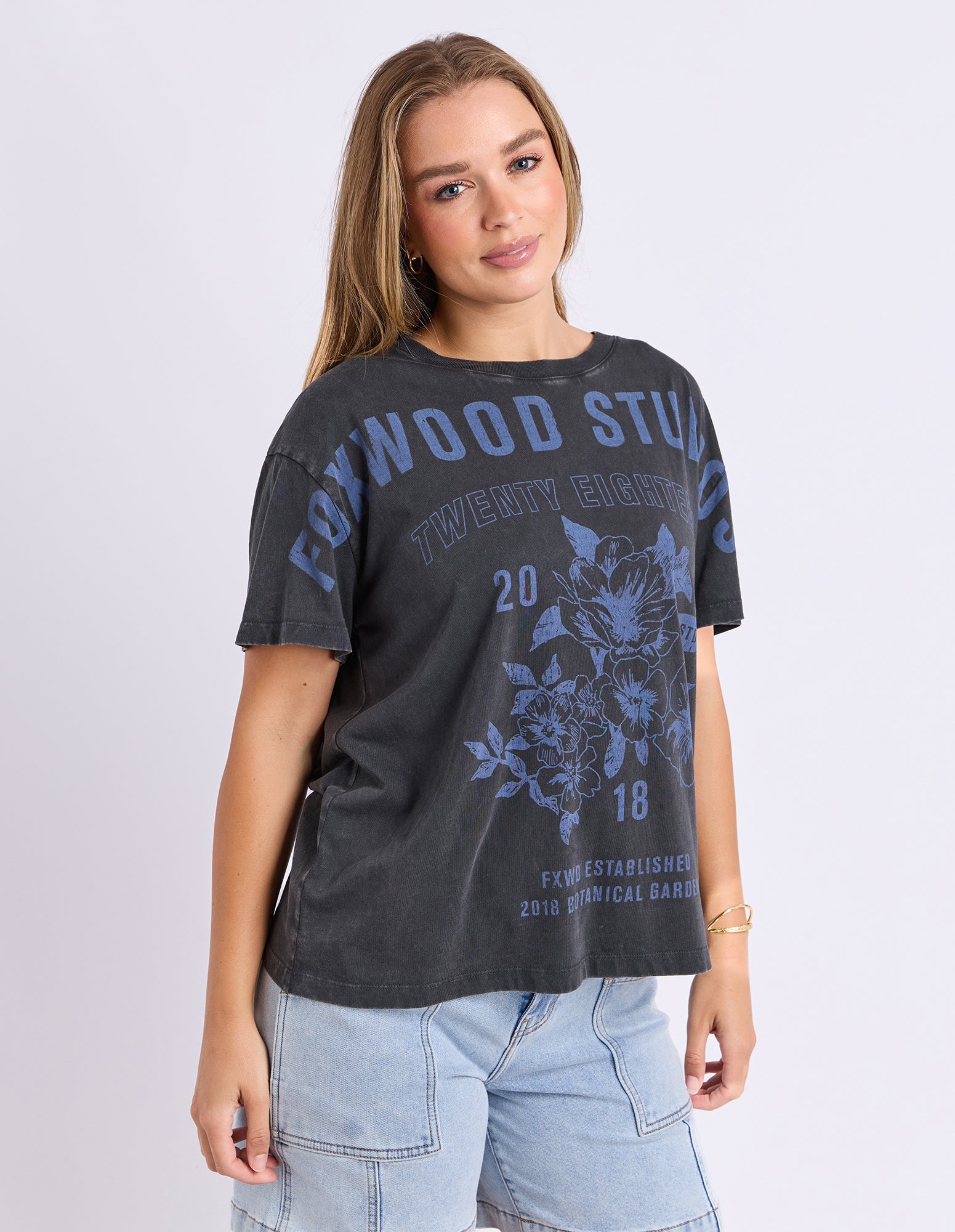 Woman wearing a black t-shirt with blue graphics and text on a light gray background