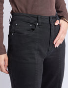 Person wearing black pants with a plain background