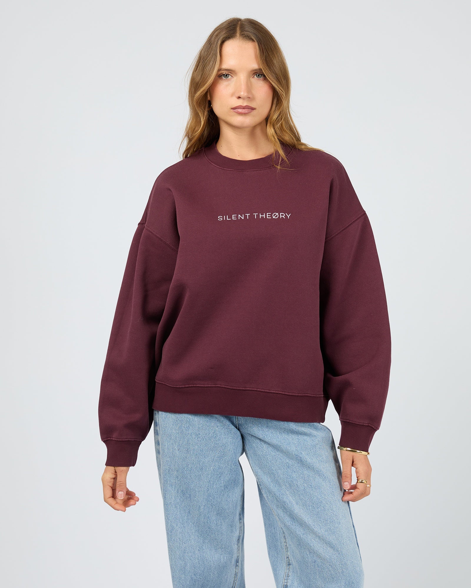 Person wearing a maroon sweatshirt with 'Silent Theory' logo on a light gray background