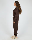Person wearing a brown tracksuit on a white background