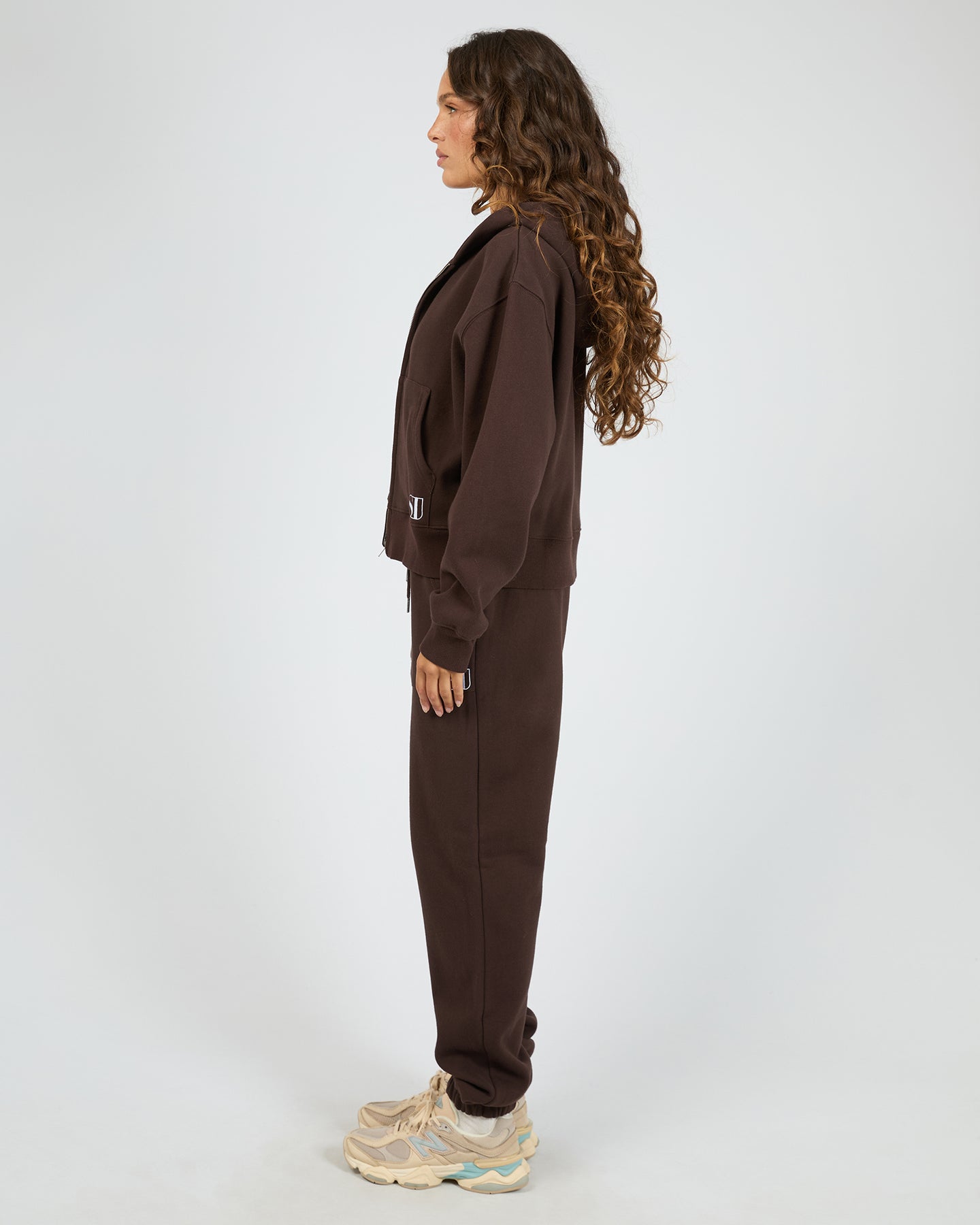 Person wearing a brown tracksuit on a white background