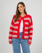 Woman wearing a red and white striped cardigan on a gray background