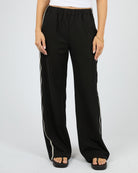 Black wide-leg pants with white stripes on a plain background