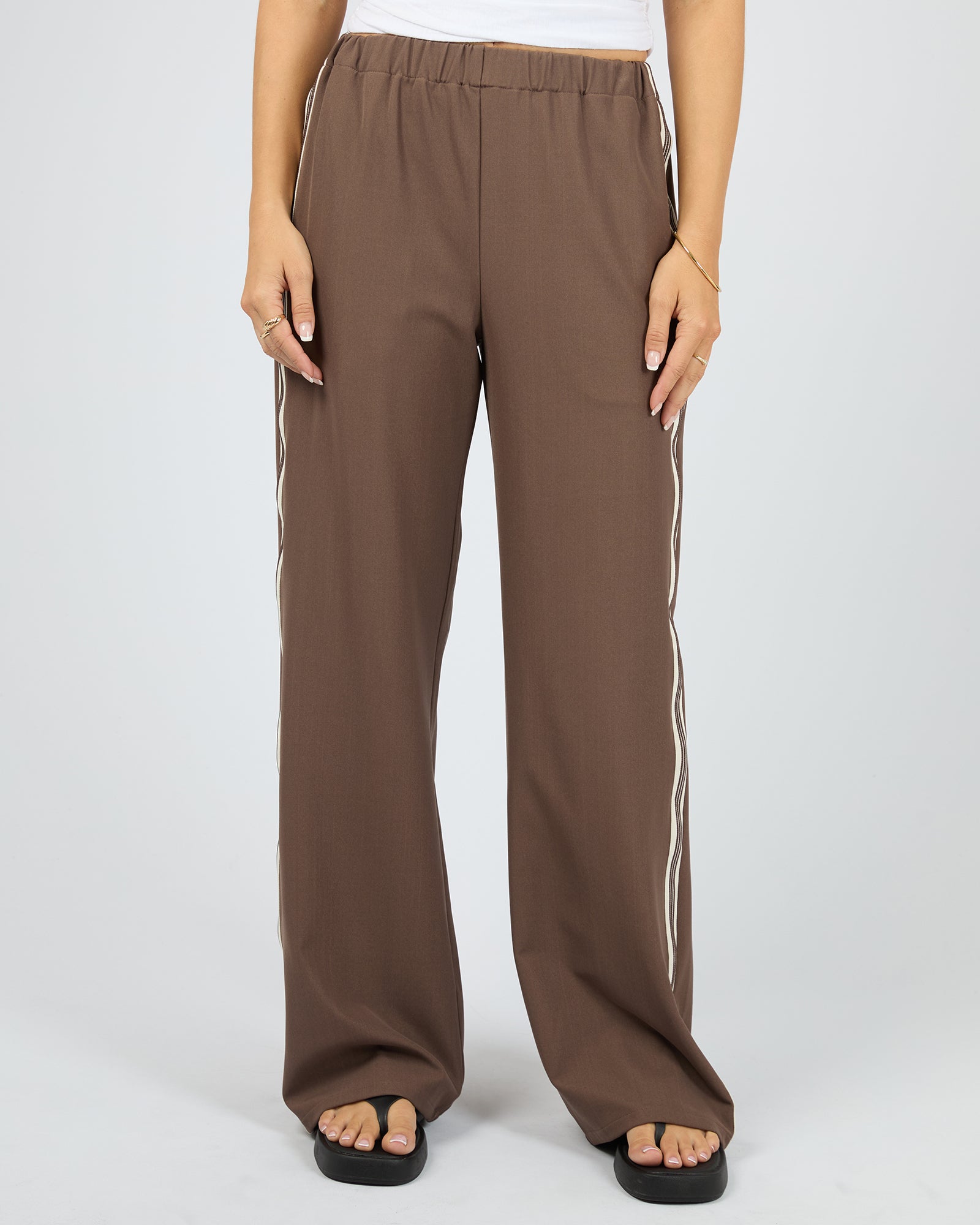 Brown wide-leg pants with white stripes on a white background