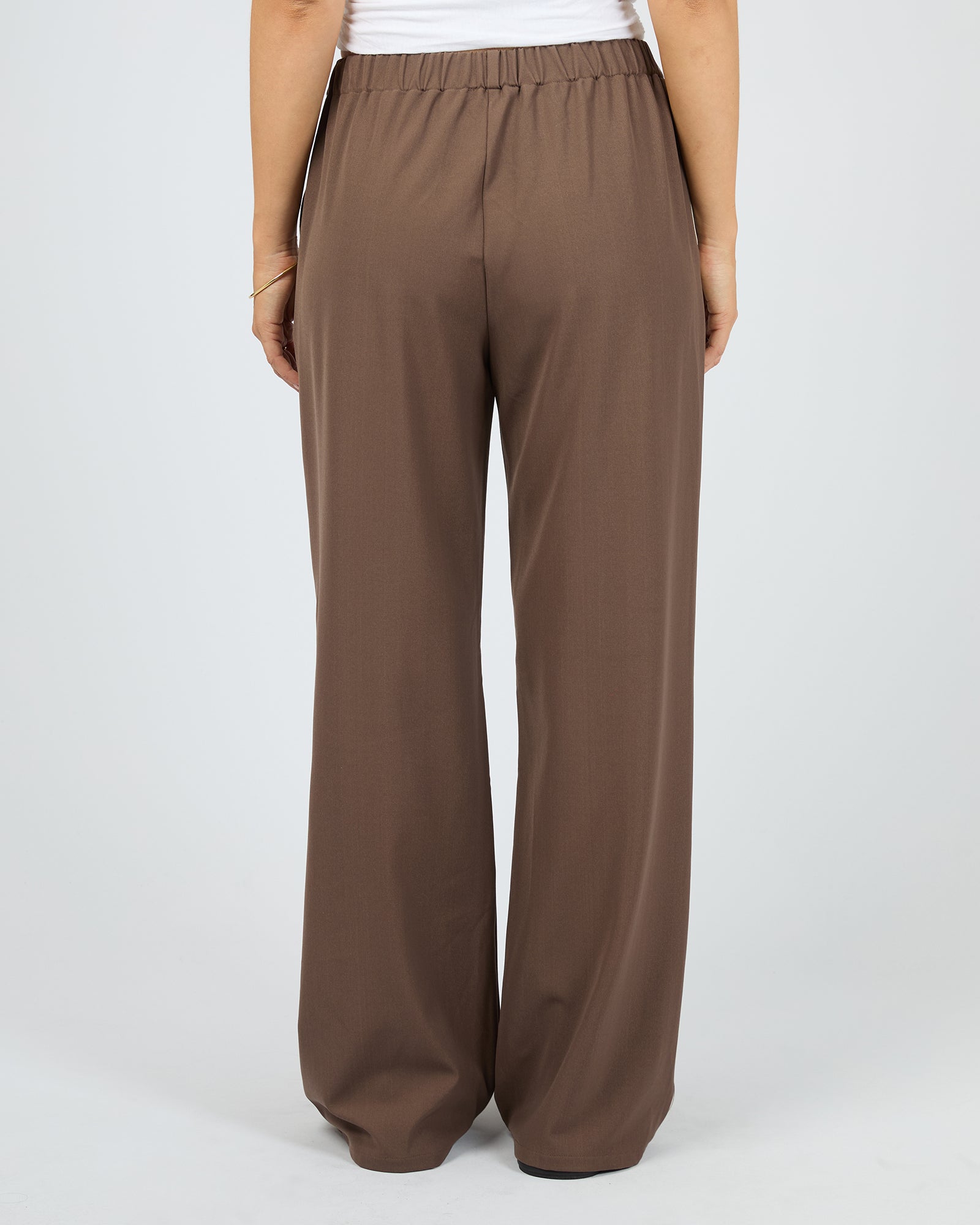 Brown wide-leg pants worn by a person on a light gray background