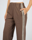 Brown pants with white stripes on a plain background