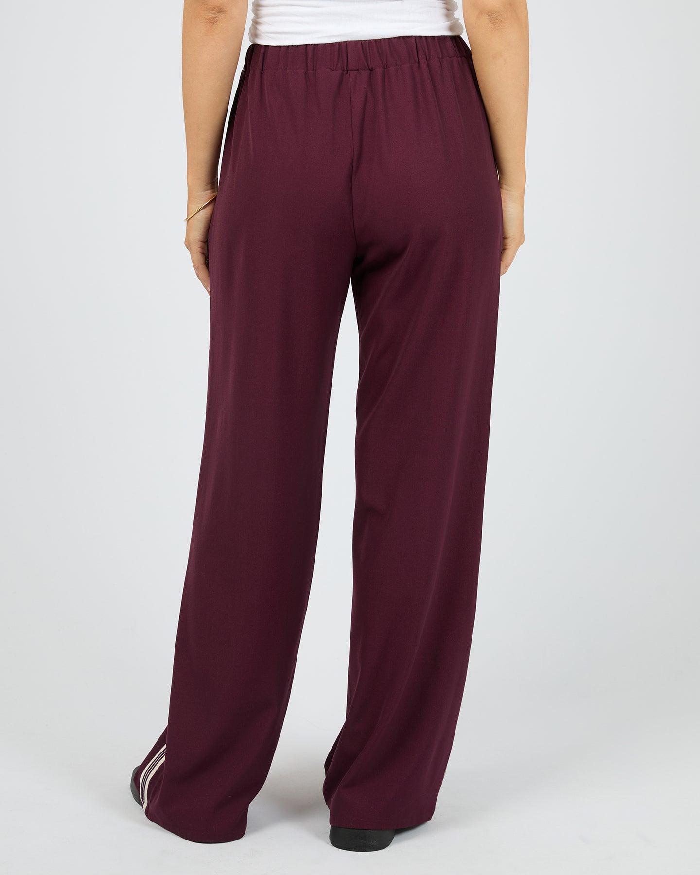 Maroon pants worn by a person on a white background